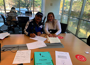 Personas durante la firma de un contrato de financiamiento hipotecario.