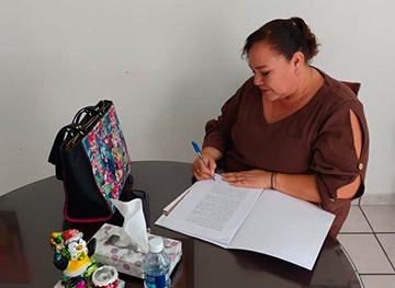 Personas formalizando un crédito bancario mediante la firma del contrato.